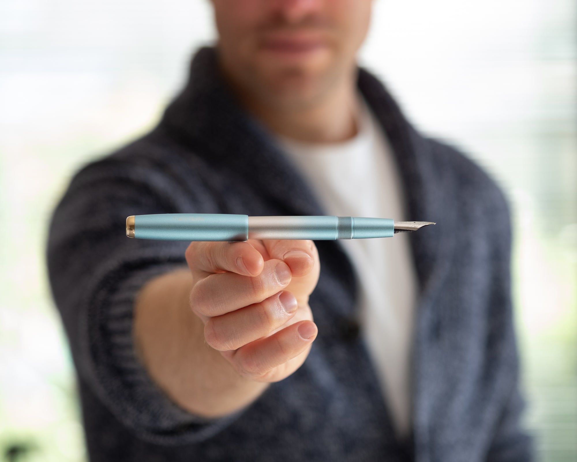 Tom balancing a fountain pen on his finger