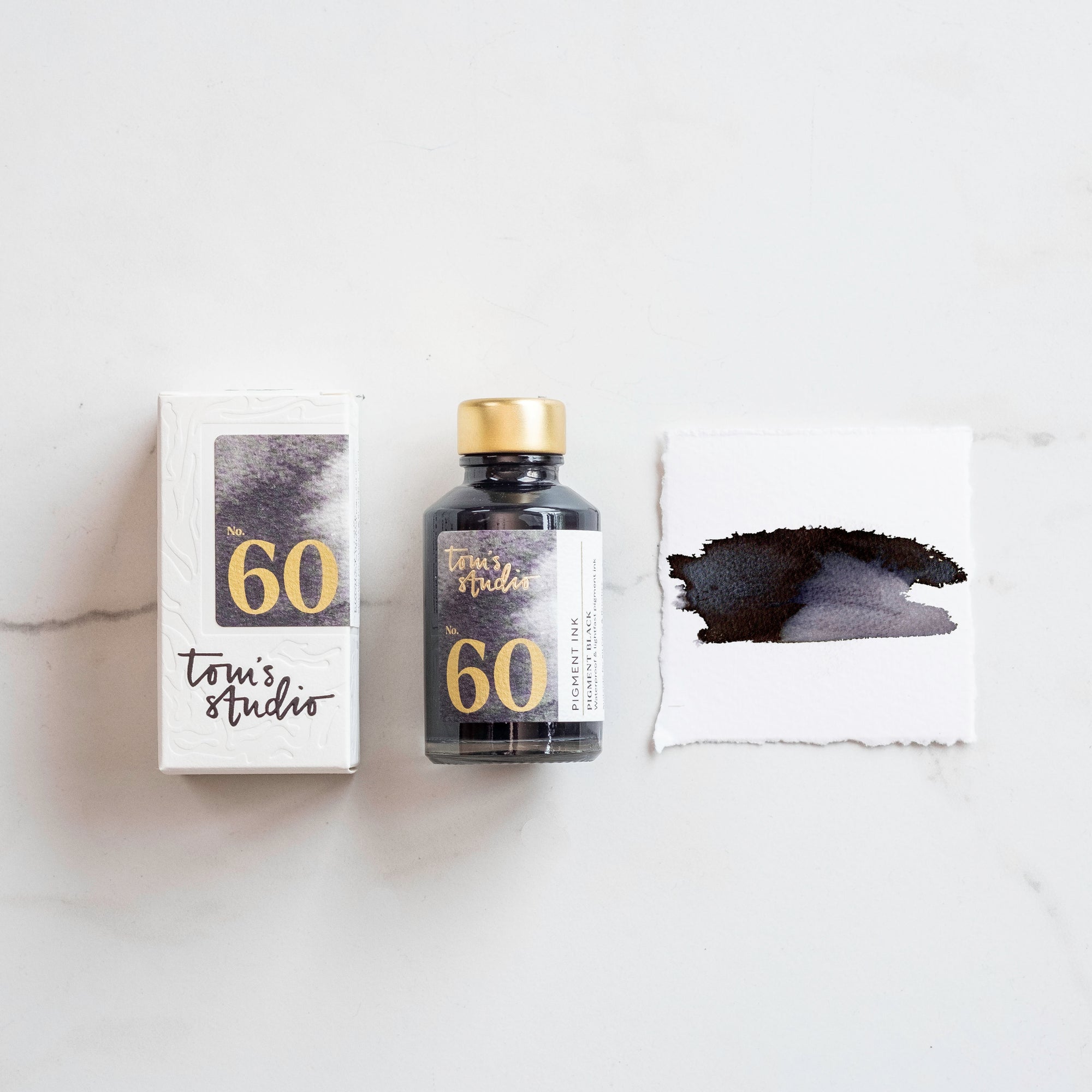 A bottle of black waterproof pigment ink alongside the box and a colour swatch