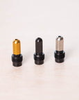 A group shot of the silver, black and gold tip holders displayed on a plain light background.