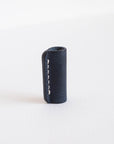 Midnight leather Lumos grip and rollstop standing upright on a white background, showing hand-stitched detail.
