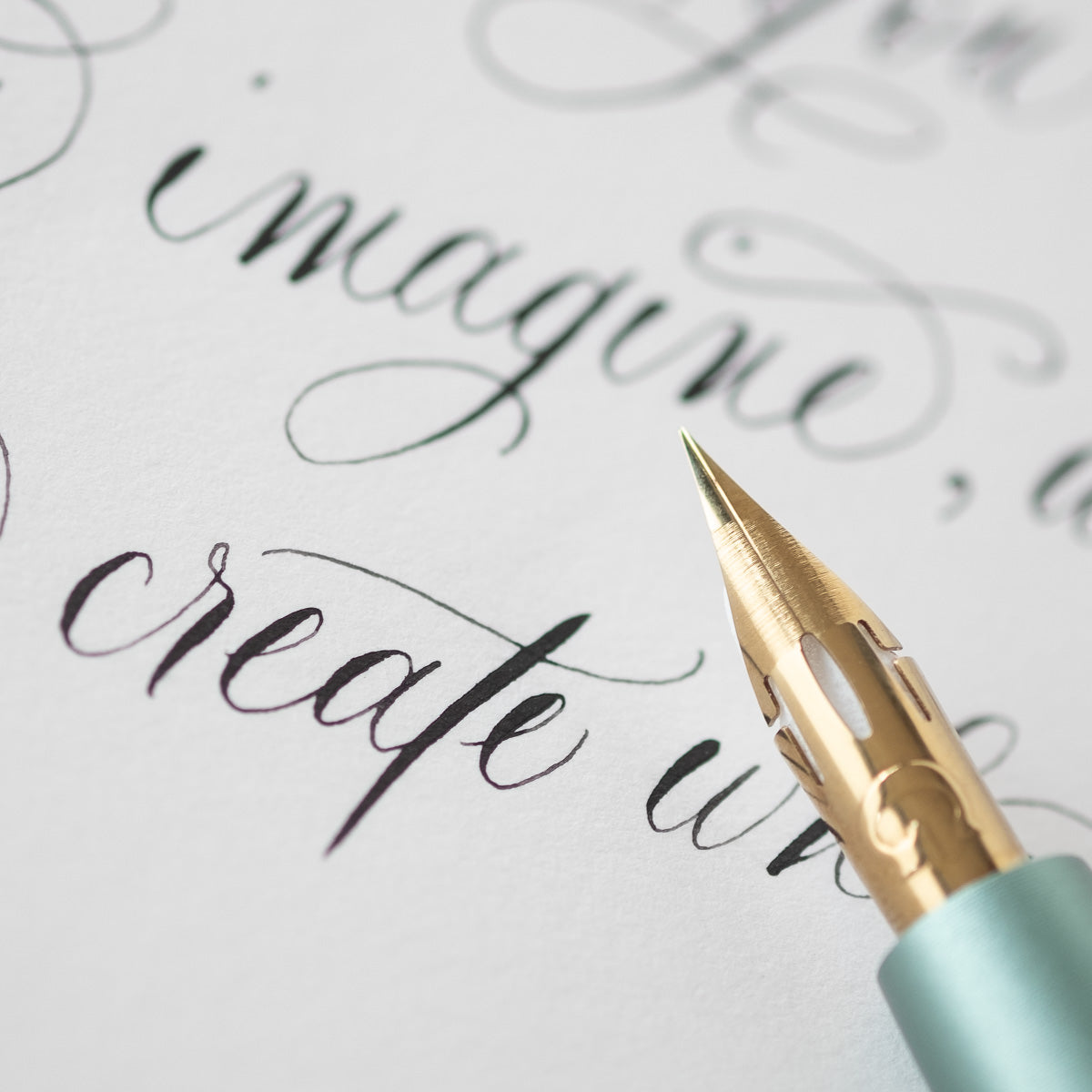 The Pro-Flex fountain pen nib with modern calligraphy in the  background