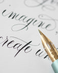 The Pro-Flex fountain pen nib with modern calligraphy in the background