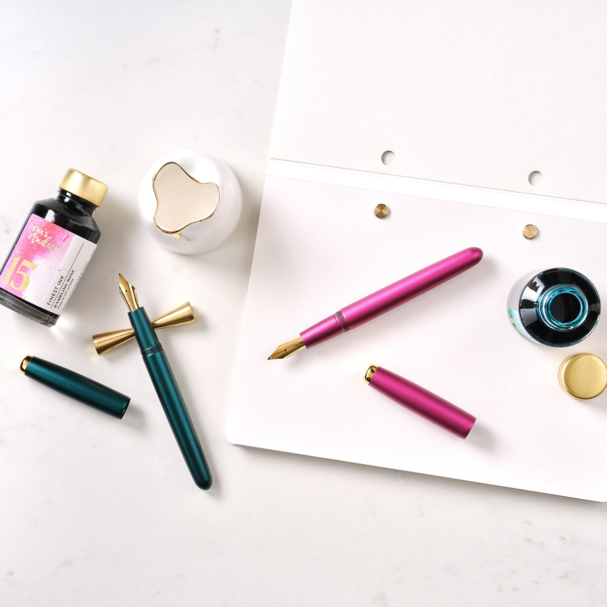 Zoom fountain pen nib fitted in the Studio Fountain Pen in Ivy, and Fude fountain pen nib fitted in the Studio Fountain Pen in Mulberry, pictured with ink and accessories