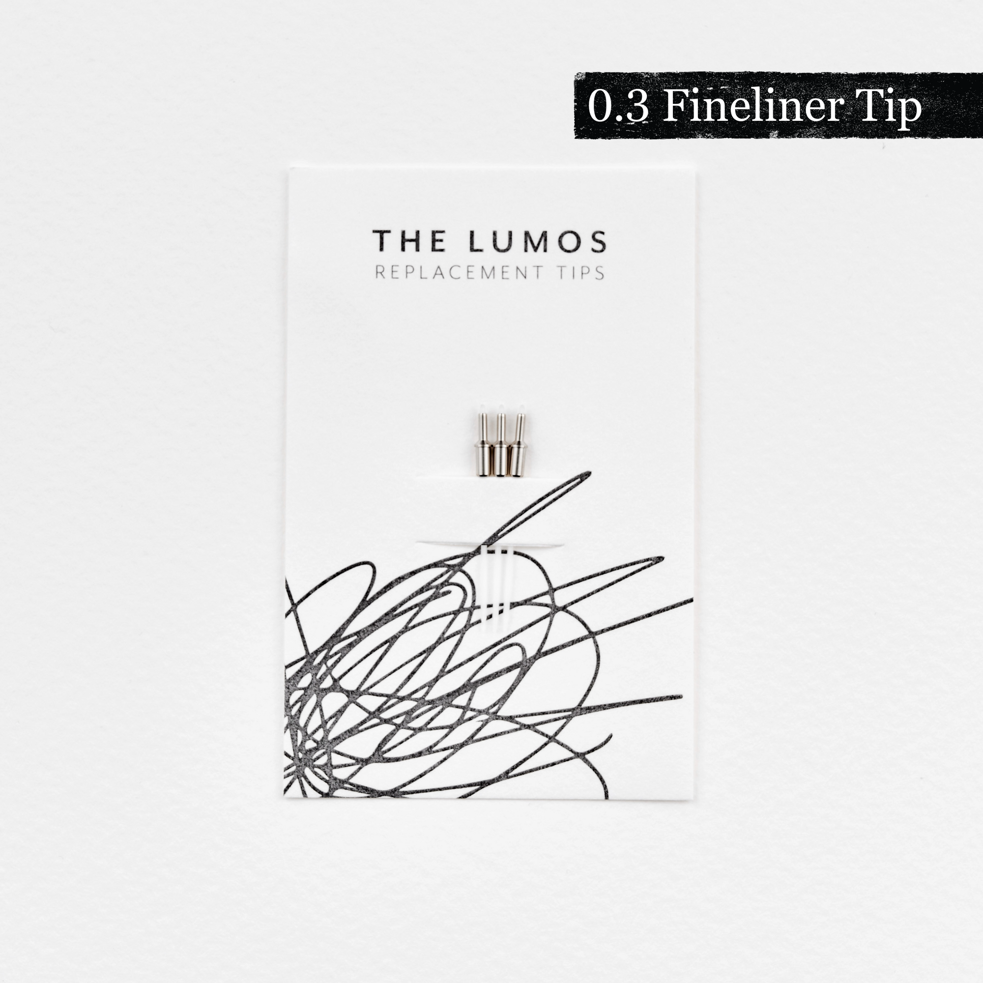 A pack of three Lumos 0.3mm fineliner replacement tips attached to a white backing card. The card features 'THE LUMOS REPLACEMENT TIPS' in uppercase black letters at the top, with an abstract black ink scribble design in the lower half. A black textured label in the upper right corner displays '0.3 Fineliner Tip' in white text.