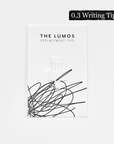 A pack of three Lumos replacement 0.3 Writing tips attached to a white backing card. The card features 'THE LUMOS REPLACEMENT TIPS' in uppercase black letters at the top, with an abstract black ink scribble design in the lower half. A black textured label in the upper right corner displays '0.3 Writing Tip' in white text.