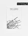 A pack of three Lumos replacement 0.5 Writing tips attached to a white backing card. The card features 'THE LUMOS REPLACEMENT TIPS' in uppercase black letters at the top, with an abstract black ink scribble design in the lower half. A black textured label in the upper right corner displays '0.5 Writing Tip' in white text.