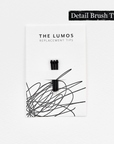 A pack of three Lumos replacement Detail Brush tips attached to a white backing card. The card features 'THE LUMOS REPLACEMENT TIPS' in uppercase black letters at the top, with an abstract black ink scribble design in the lower half. A black textured label in the upper right corner displays 'Detail Brush Tip' in white text.