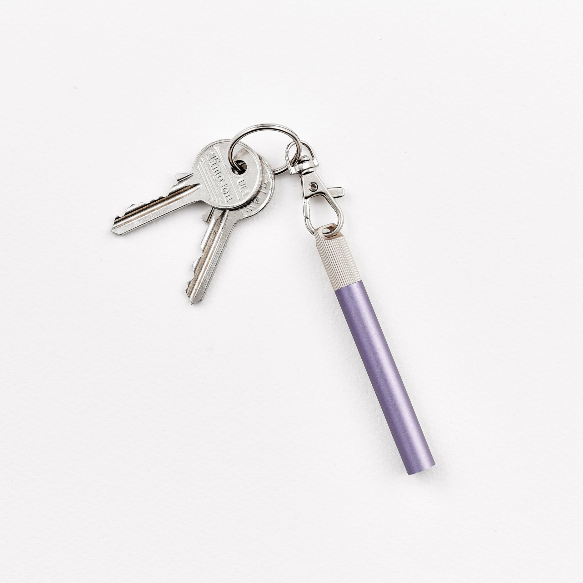 A Lumos Loop Lid attached to a Lilac Lumos Mini pen and clipped onto a keyring, displayed on a plain white background.
