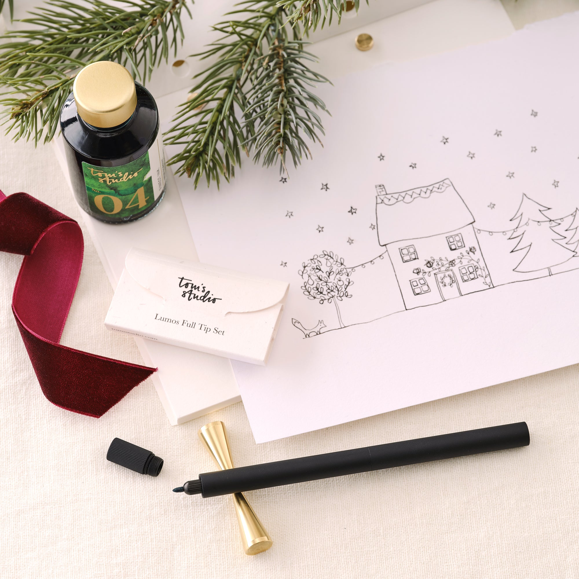 Contents of the Lumos Pro Duo Gift Set including: Lumos Pro Duo refillable pen in Black, 50ml bottle of Fountain Pen Ink in New Forest, the Studio Pad and Butterfly Brass Pen Rest