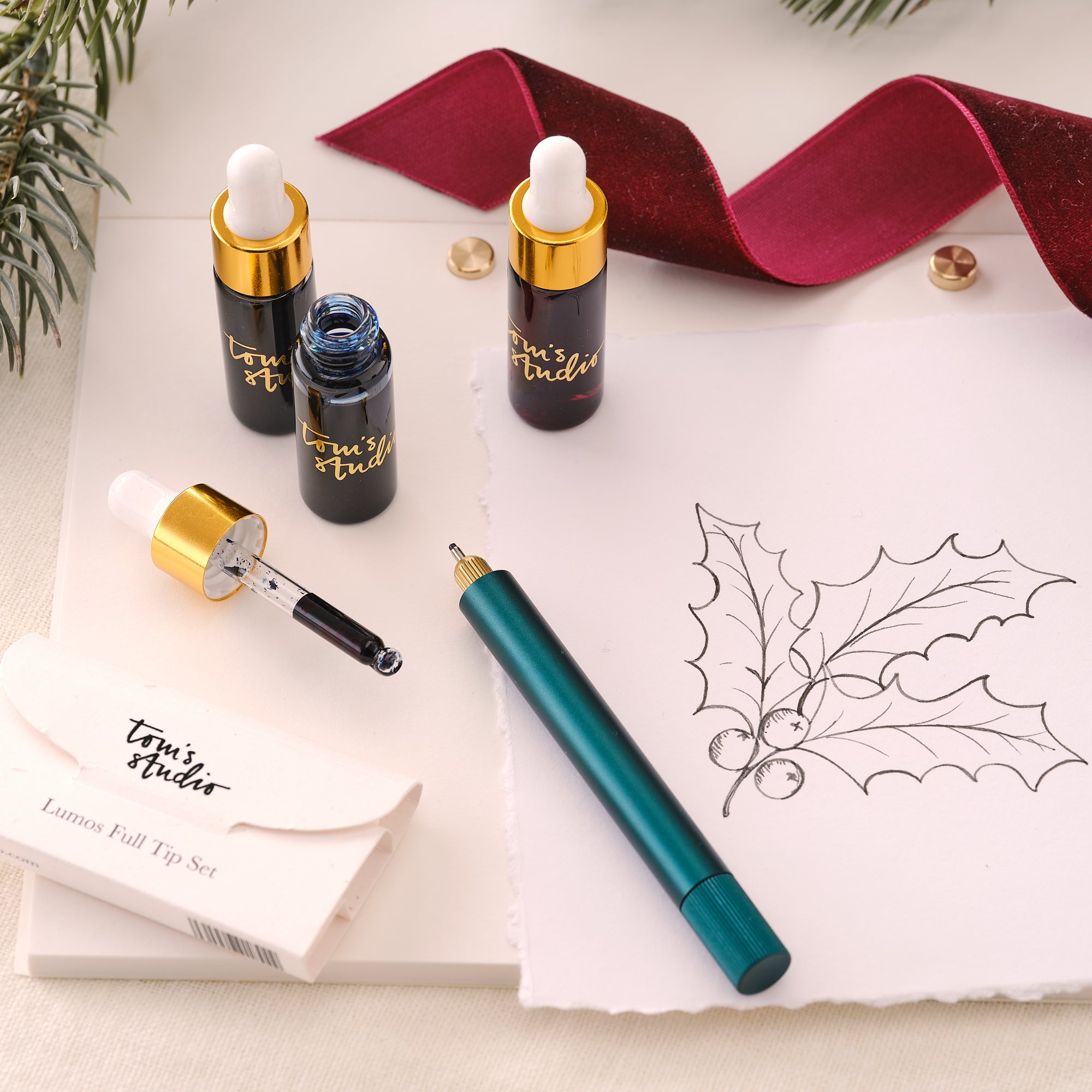 Contents of the Lumos Mini Gift Set including the Lumos Mini refillable pen in Ivy, Lumos Full Tip Set, the Studio Pad and set of three mini 5ml fountain pen inks