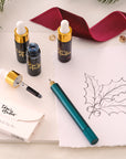 Contents of the Lumos Mini Gift Set including the Lumos Mini refillable pen in Ivy, Lumos Full Tip Set, the Studio Pad and set of three mini 5ml fountain pen inks