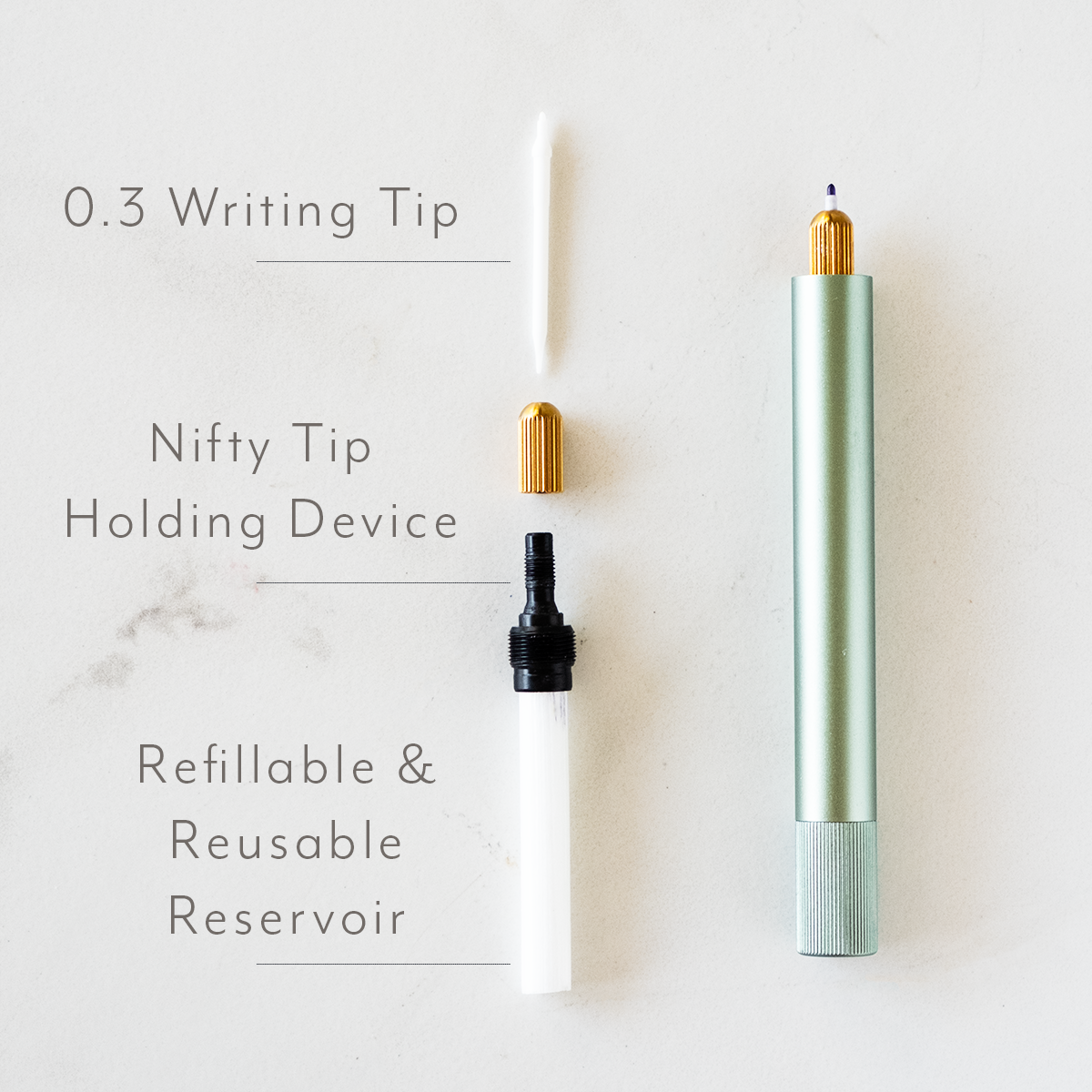 The Lumos Mini refillable pen in Sage shown with parts – writing tip, tip cover, tip holder and refillable reservoir
