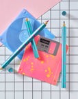 Close-up of Lumos Splash pens in Blue Raspberry colourway with pink splatter, styled with neon pink and blue floppy disks on a grid background.
