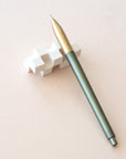Tom's Studio Mechanical Pencil in Sage, resting on the World's Best Eraser