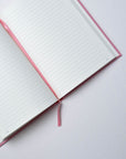 Semikolon A5 notebook in Flamingo pink with ruled pages, page marker ribbon and premium linen bound cover.