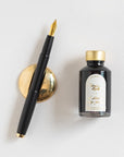 Contents of the Studio Fountain Pen Gift Set including Studio Fountain pen in Black with Medium Gold nib, Deep Black Fountain Pen Ink and Solid Brass Pen Rest.