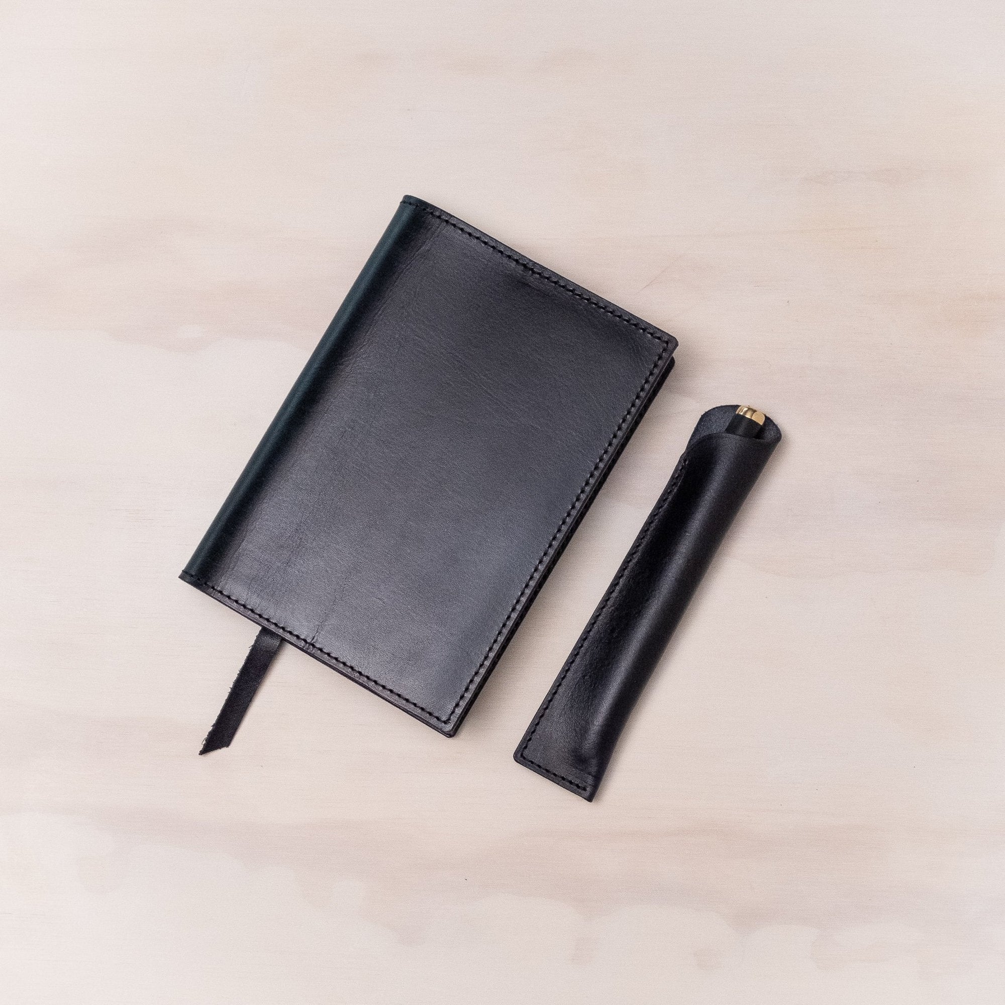 Leather Pen Sleeve for the Lumos Pro in Black shown with matching leather notebook cover and the Studio Fountain Pen in Black