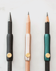 The Poise Pencil Grip Extender in (left to right) Black, Blush and Ivy. Shown on a standard pencil.
