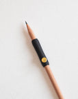 The Poise Pencil Grip Extender in Black shown on a standard pencil.
