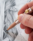The Poise Pencil Grip Extender in Blush. Shown in use on a pencil illustration.