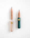 The Poise Pencil Grip Extender in (left to right) Blush and Ivy. Shown on a short pencil.