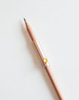 The Poise Pencil Grip Extender in Blush shown on a standard pencil.