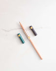 The Poise Pencil Grip Extender in (left to right) Ivy, Blush and Black. Shown on a standard pencil.