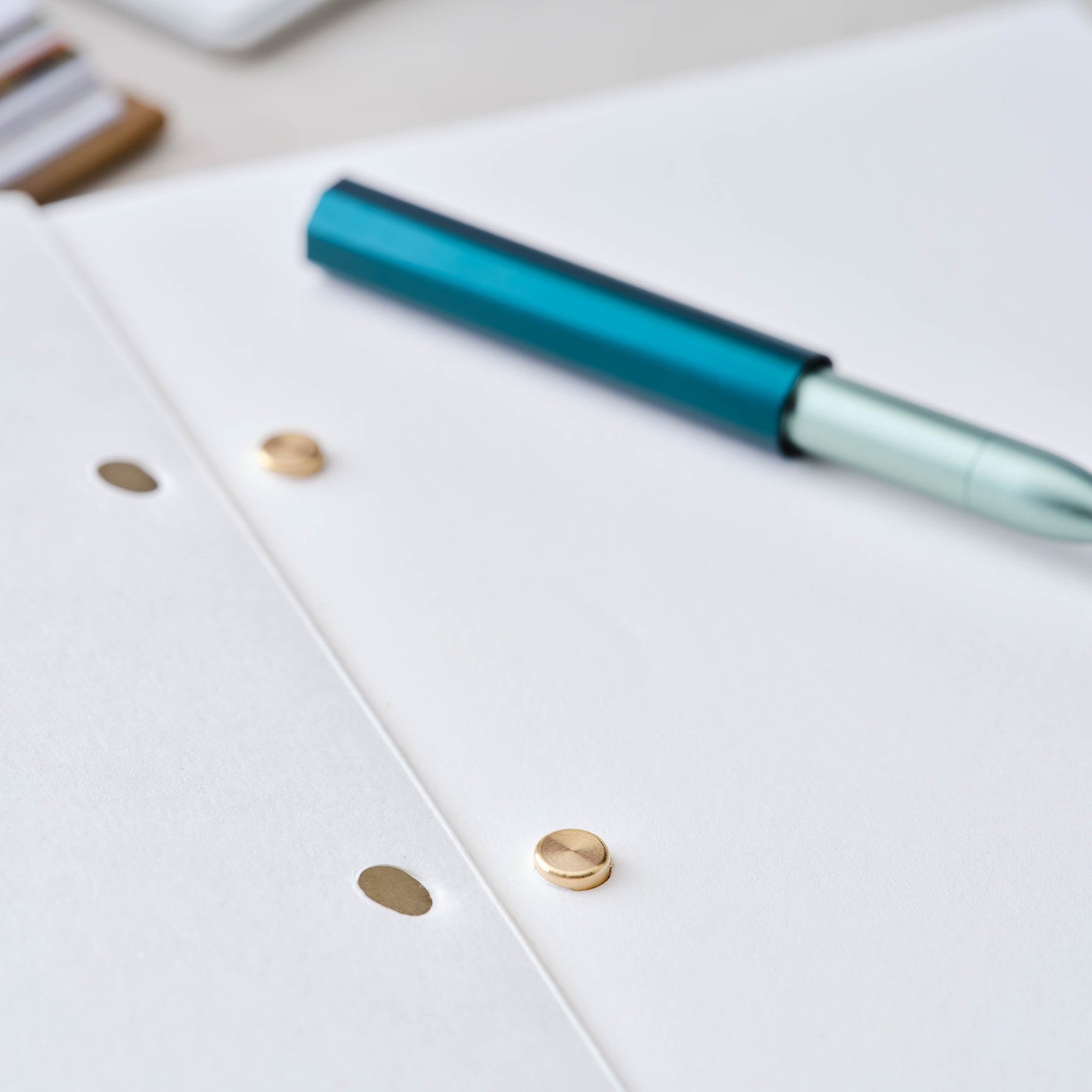 Detail shot of solid brass studs in use in the open Studio Pad refillable, customisable notebook and organiser