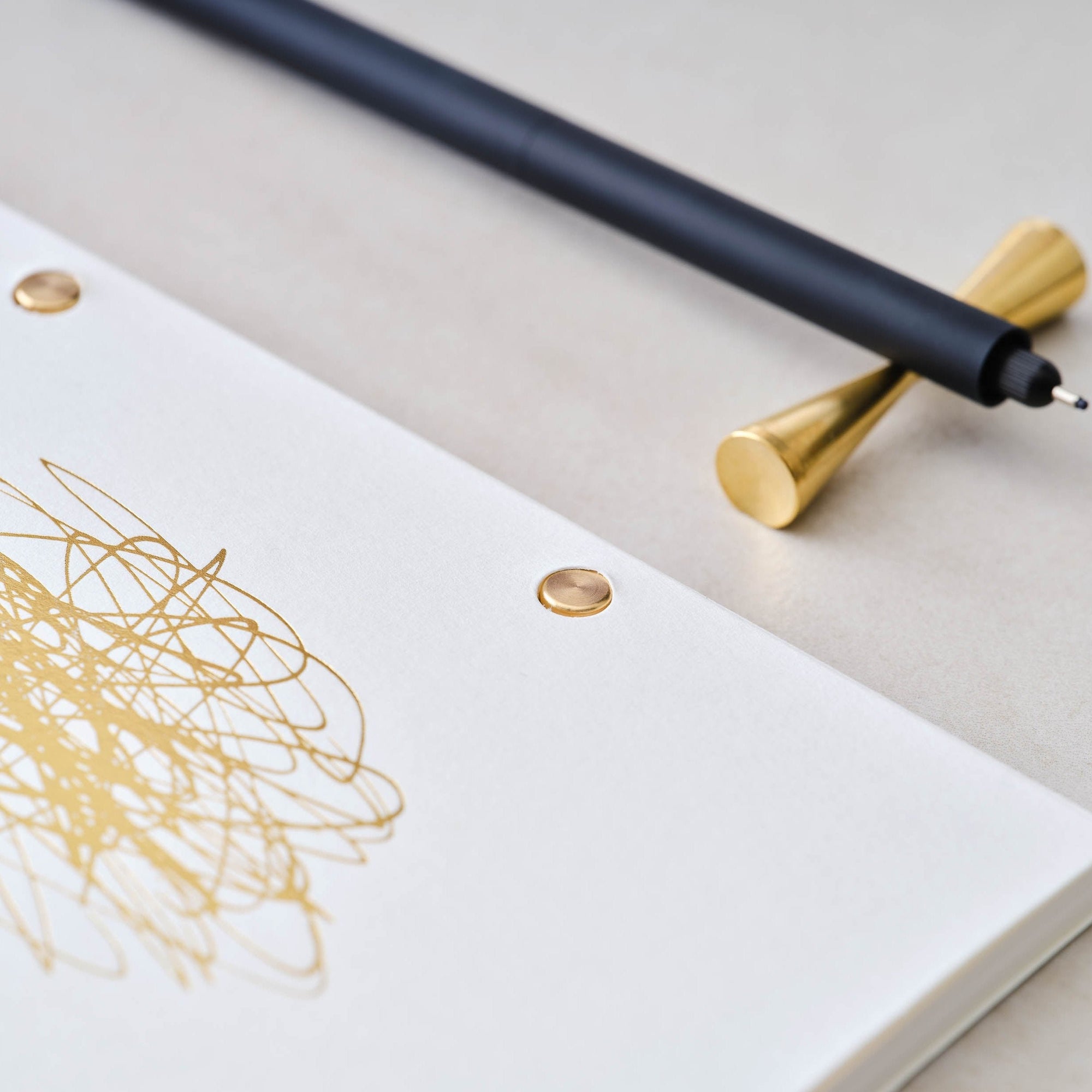 Detail shot of the solid brass studs in use in the Studio Pad refillable, customisable notebook and organiser