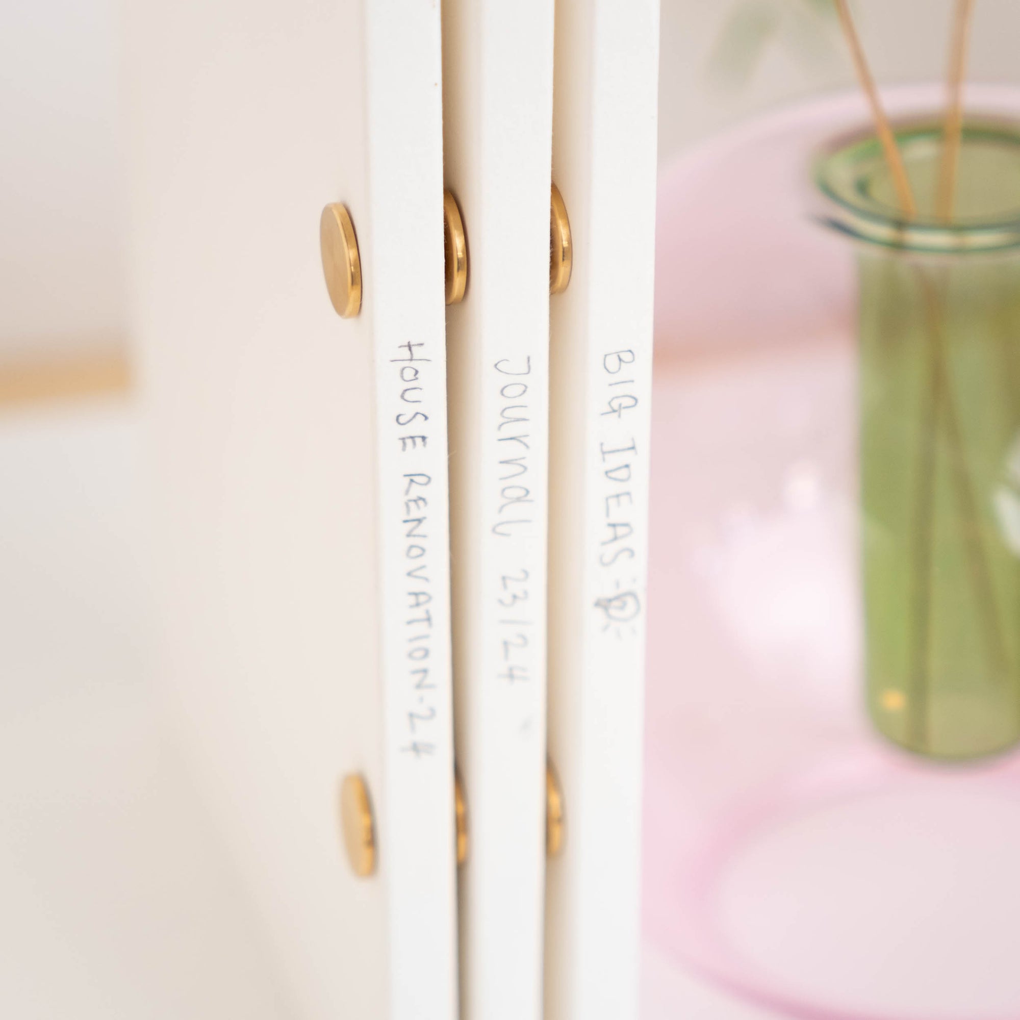 A row of spines, each with a different title, all The Studio Pad refillable, customisable notebook and organiser