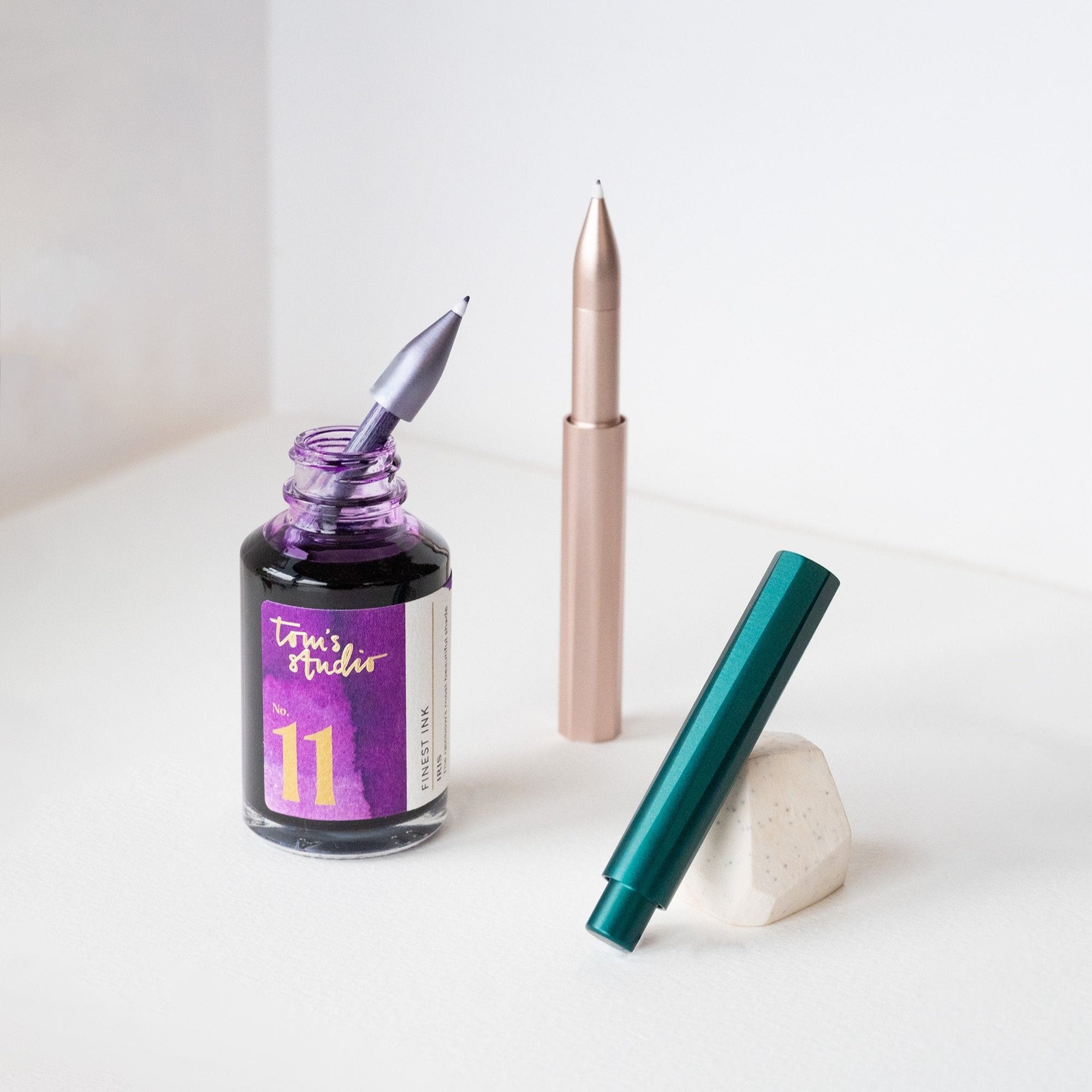 The Wren refillable everyday writing pen in (left to right) Lilac, Blush and Ivy with a bottle of Iris Fountain Pen Ink – showing how to fill the ink reservoir