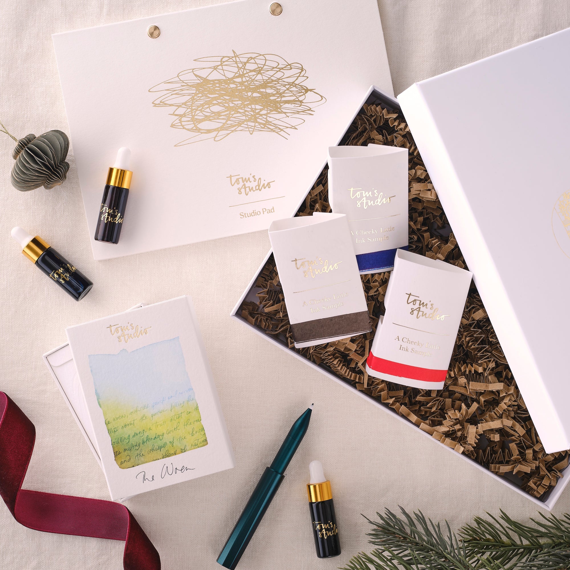 Contents of the Wren gift set including: set of three mini fountain pen inks, the studio pad and Wren refillable writing pen, with beautiful gold foiled gift box