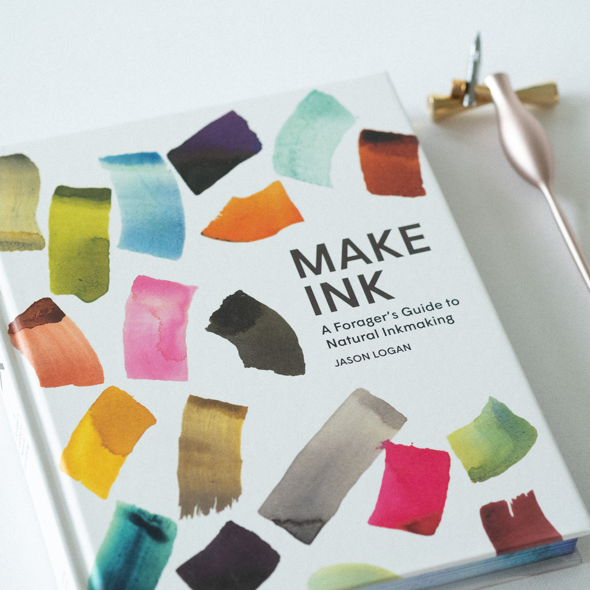 Make Ink by Jason Logan book cover shown with the Carrot Calligraphy Pen and Butterfly Brass Pen Rest