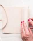 A person rolling the Leather Pen Roll handmade by Edward de Lacy