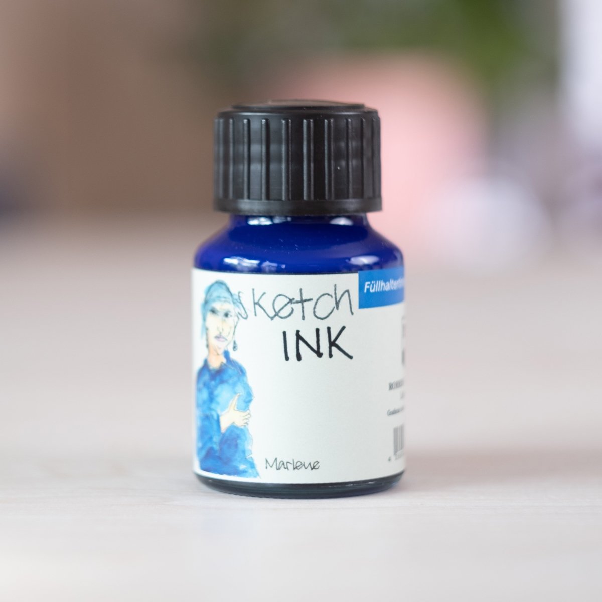 Marlene - sketchINK® a bottle of blue ink on a table