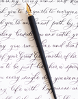The Original Flourish Straight Calligraphy Pen in Black shown on a page of calligraphy