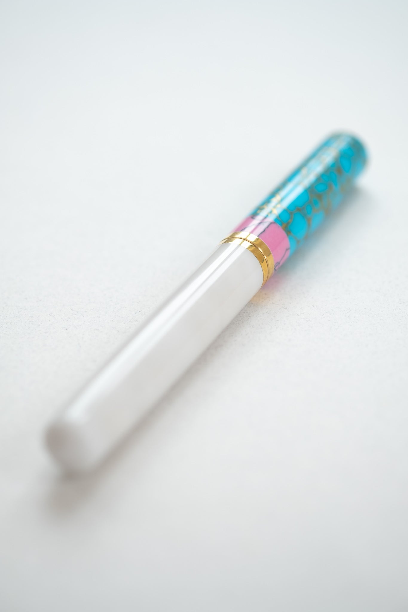 Pink + Turquoise Studio Fountain Pen close up on a white desk