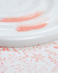 Detail shot of the Fine Bone China Artist's Palette by Wendy Tournay with paint on and watercolour background