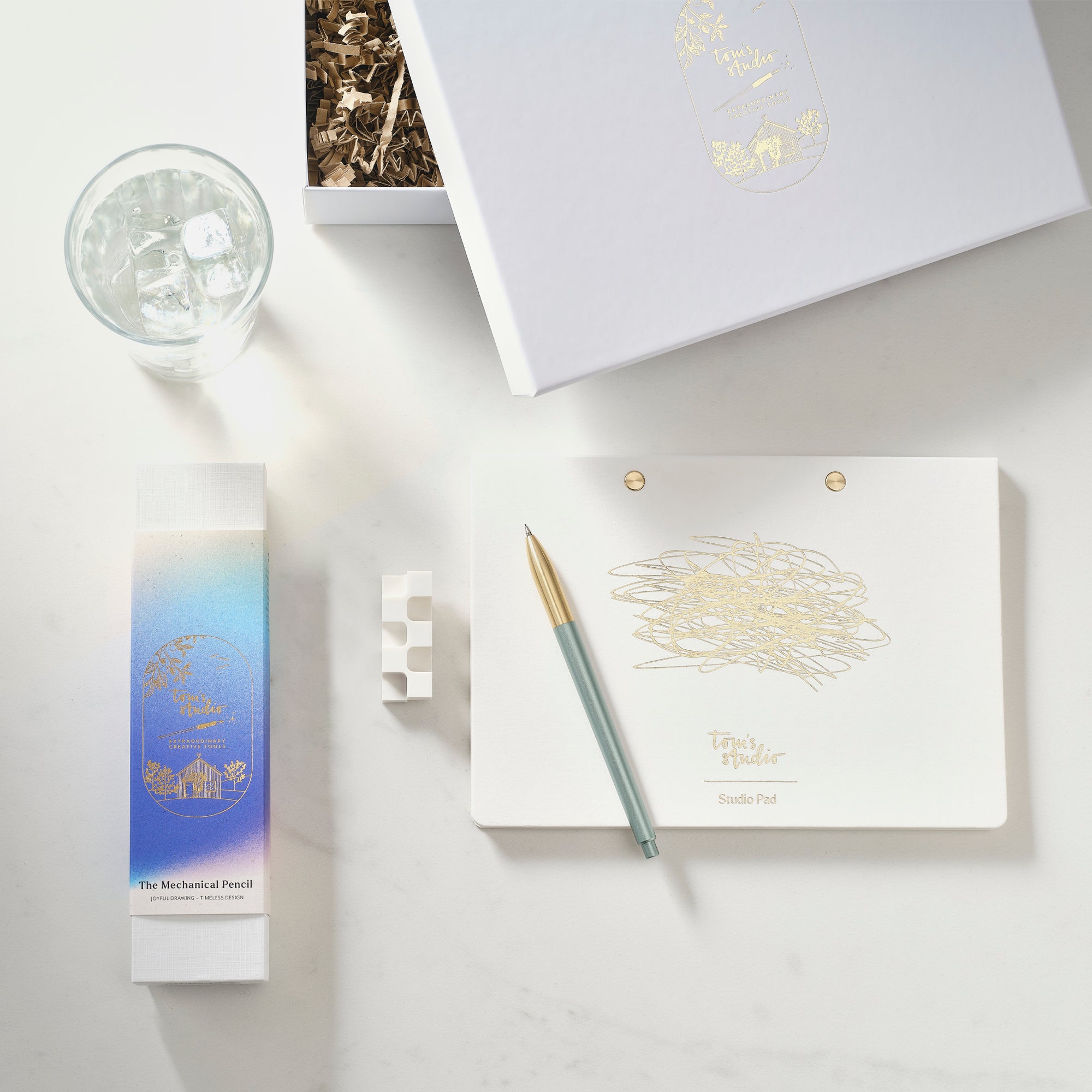 mechanical pencil gift set items including a mechanical pencil, notebook, and small box on a light surface.