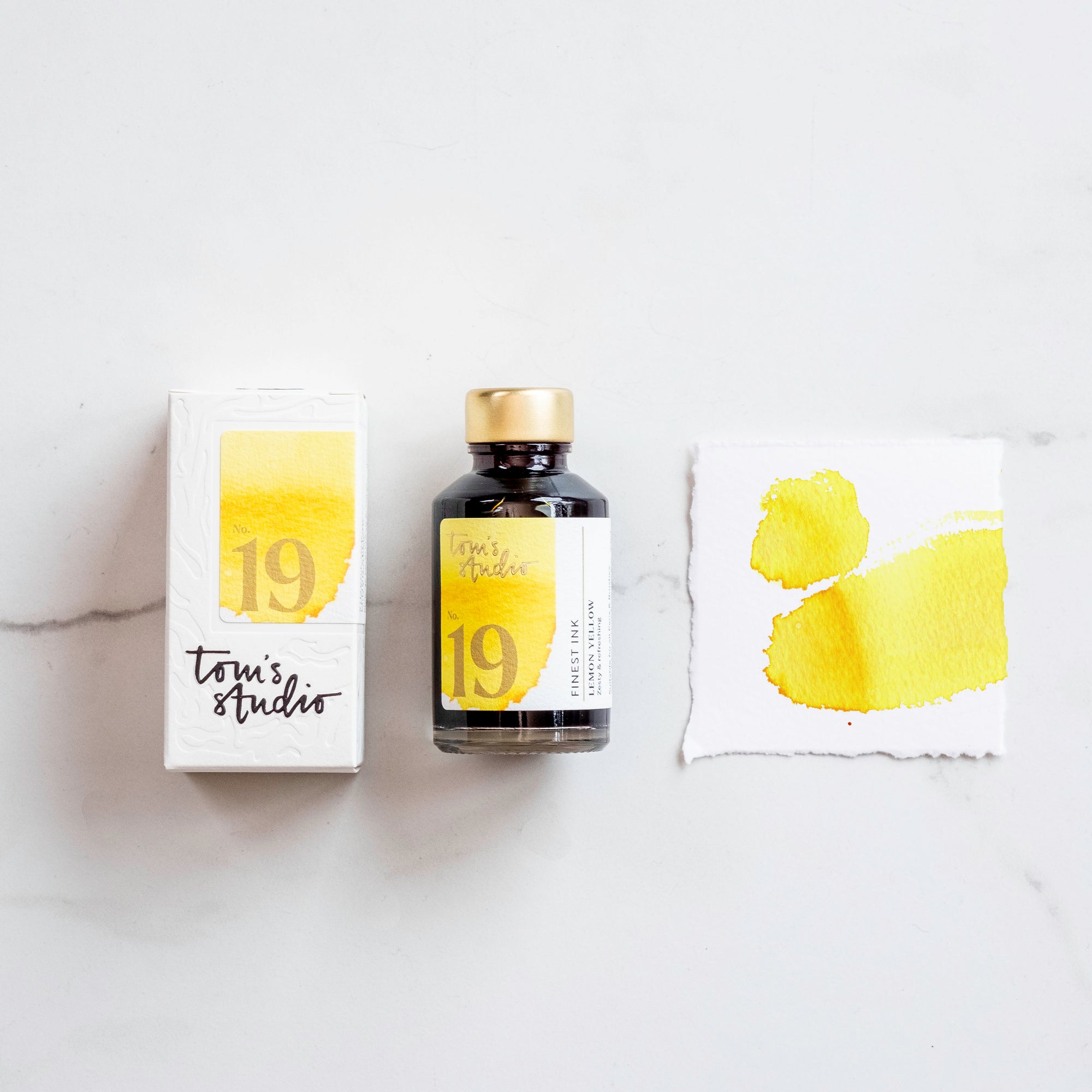 Lemon yellow fountain pen ink showing the bottle on a table alongside the box and a colour swatch