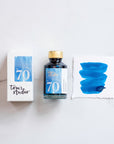 Tom's Studio Kingfisher Shimmer Fountain Pen Ink with two pens with inky goodness on paper with an ink swatch demonstrating the colour