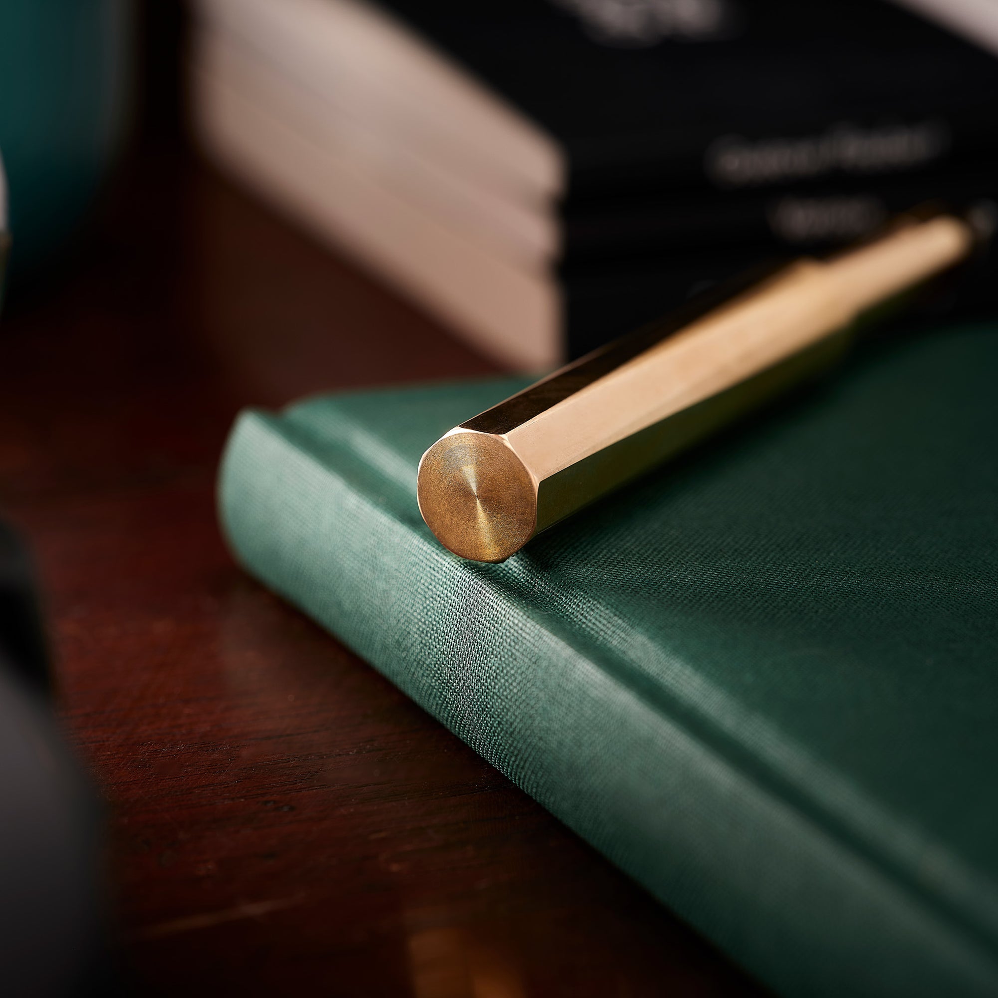 Close-up of the end of the Brass Wren lid, highlighting its solid octagonal brass lid on a green notebook.