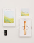 Brass Wren in its box, a small ink bottle, and a getting started guide, on a light background.
