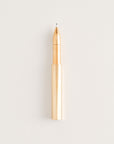 Brass Wren pen with the cap posted on the end, shown on a light background.