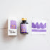 Tom's Studio Lavender Fountain Pen Ink – bottle with gold lid, boxed packaging featuring a purple and gold label marked '22', and a swatch of the vibrant lavender ink on textured paper.