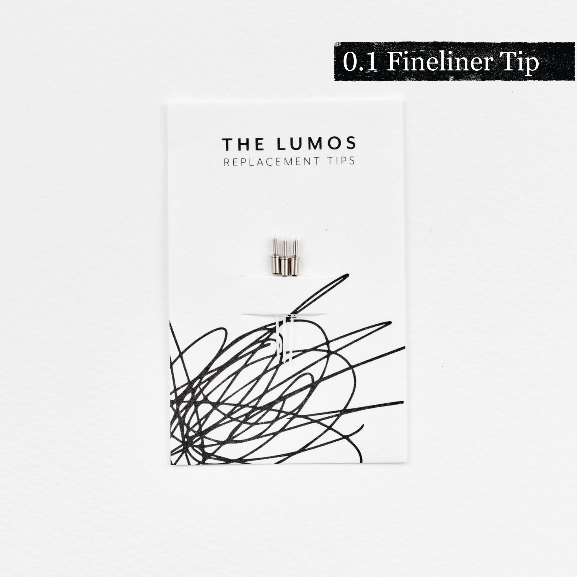 A pack of three Lumos 0.1mm fineliner replacement tips attached to a white backing card. The card features 'THE LUMOS REPLACEMENT TIPS' in uppercase black letters at the top, with an abstract black ink scribble design in the lower half. A black textured label in the upper right corner displays '0.1 Fineliner Tip' in white text. 