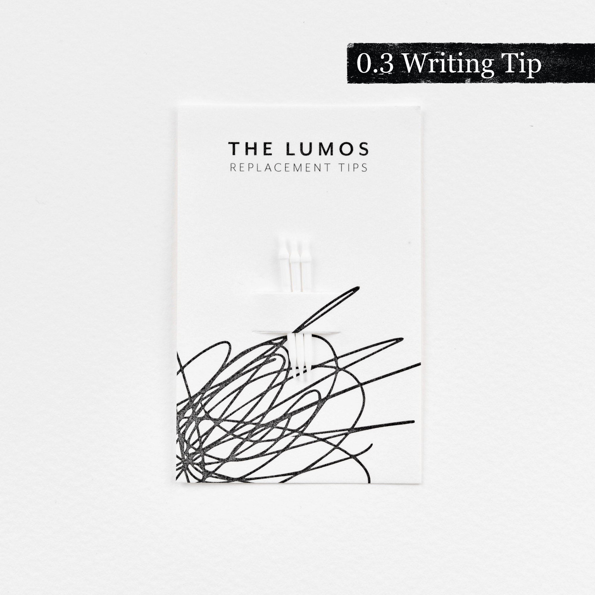 A pack of three Lumos replacement 0.3 Writing tips attached to a white backing card. The card features &#39;THE LUMOS REPLACEMENT TIPS&#39; in uppercase black letters at the top, with an abstract black ink scribble design in the lower half. A black textured label in the upper right corner displays &#39;0.3 Writing Tip&#39; in white text. 