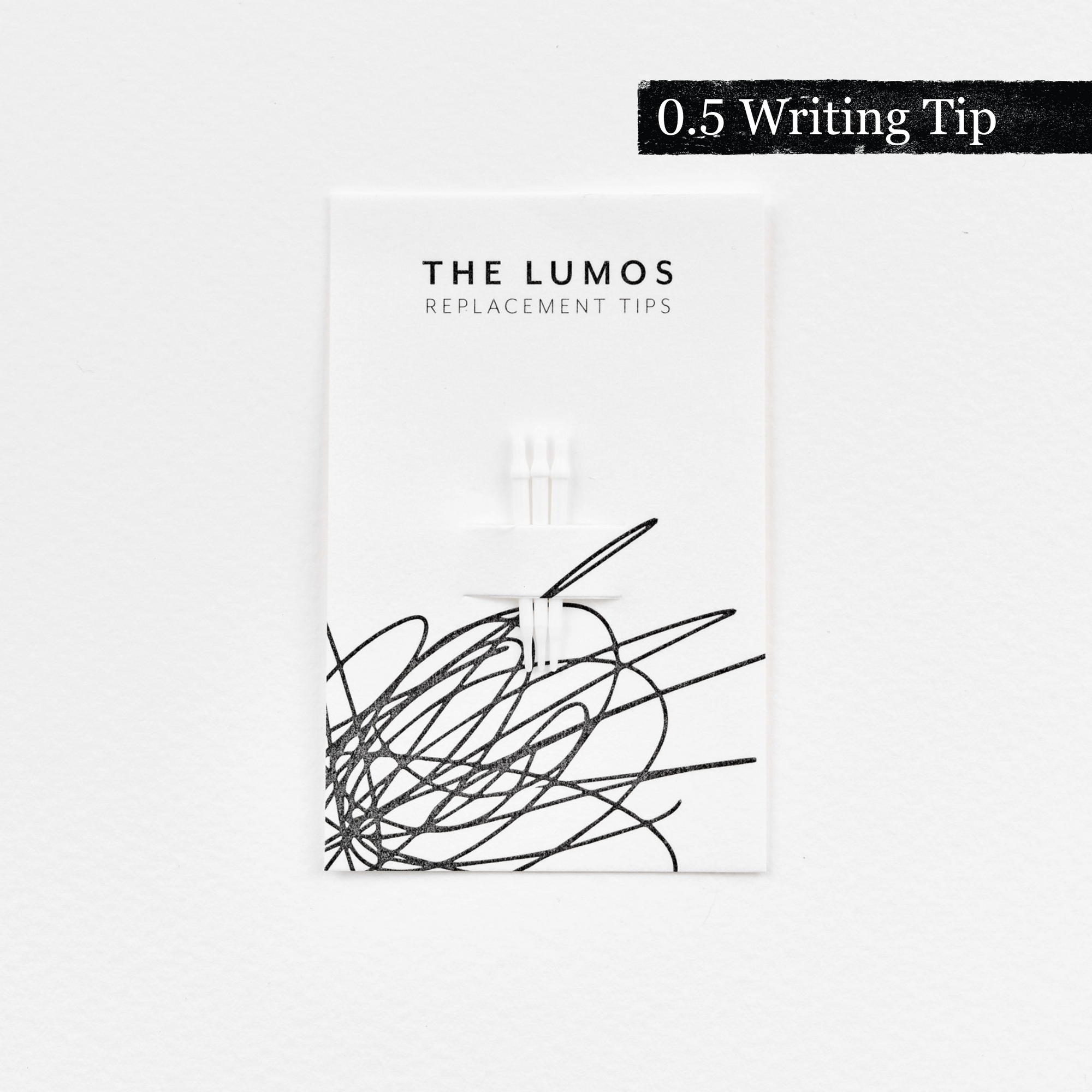 A pack of three Lumos replacement 0.5 Writing tips attached to a white backing card. The card features &#39;THE LUMOS REPLACEMENT TIPS&#39; in uppercase black letters at the top, with an abstract black ink scribble design in the lower half. A black textured label in the upper right corner displays &#39;0.5 Writing Tip&#39; in white text. 