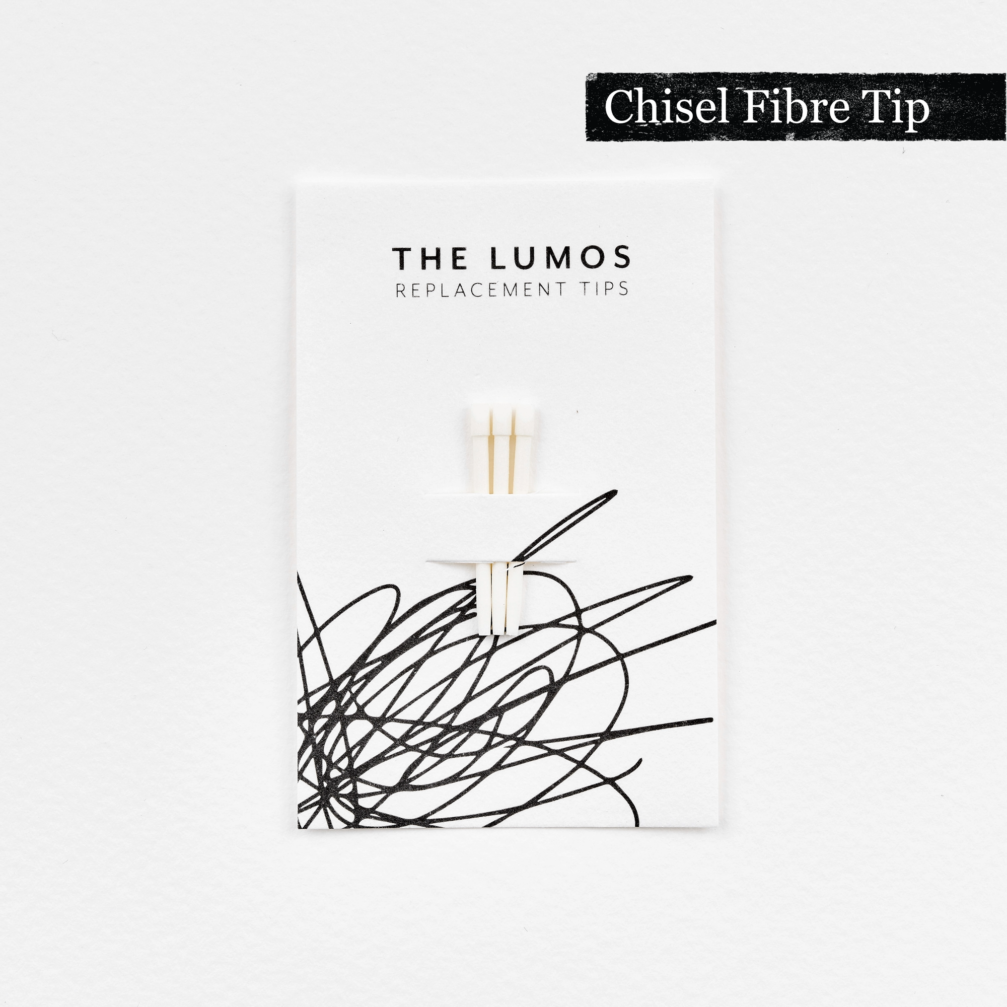 A pack of three Lumos replacement Chisel Fibre tips attached to a white backing card. The card features &#39;THE LUMOS REPLACEMENT TIPS&#39; in uppercase black letters at the top, with an abstract black ink scribble design in the lower half. A black textured label in the upper right corner displays &#39;Chisel Fibre Tip&#39; in white text. 