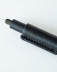 Handmade by Edward De Lacy, a leather pen grip and rollstop for the Lumos refillable pen – shown in black leather on the black Lumos